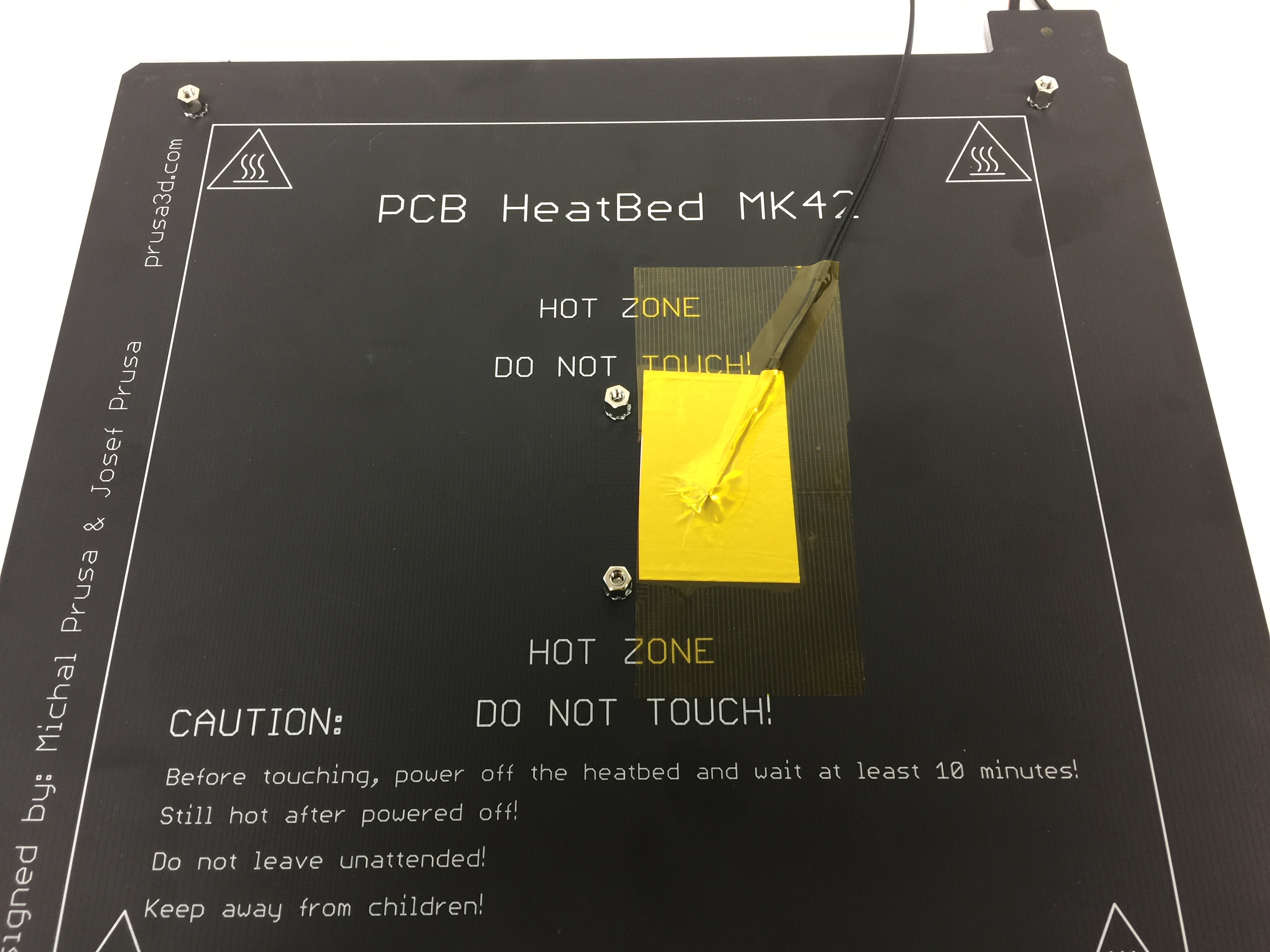 Not the two types of tape securing the thermistor. There is a layer of aluminum foil tape underneath the layer of kapton tape.